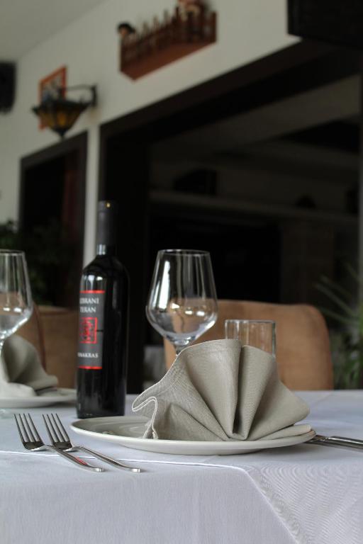 a table with a plate and a bottle of wine at Hotel Opera Jaz in Budva