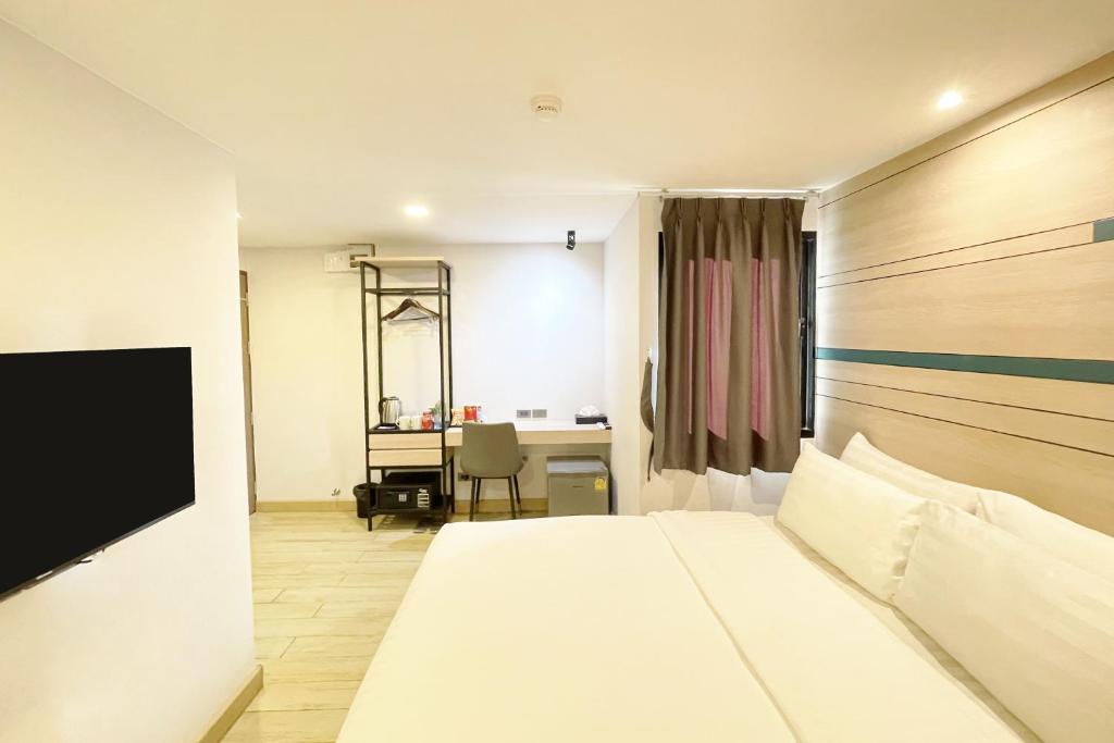 City Park Hotel Bangkok Pratunam by PCL في بانكوك: غرفة في الفندق مع سرير ومكتب
