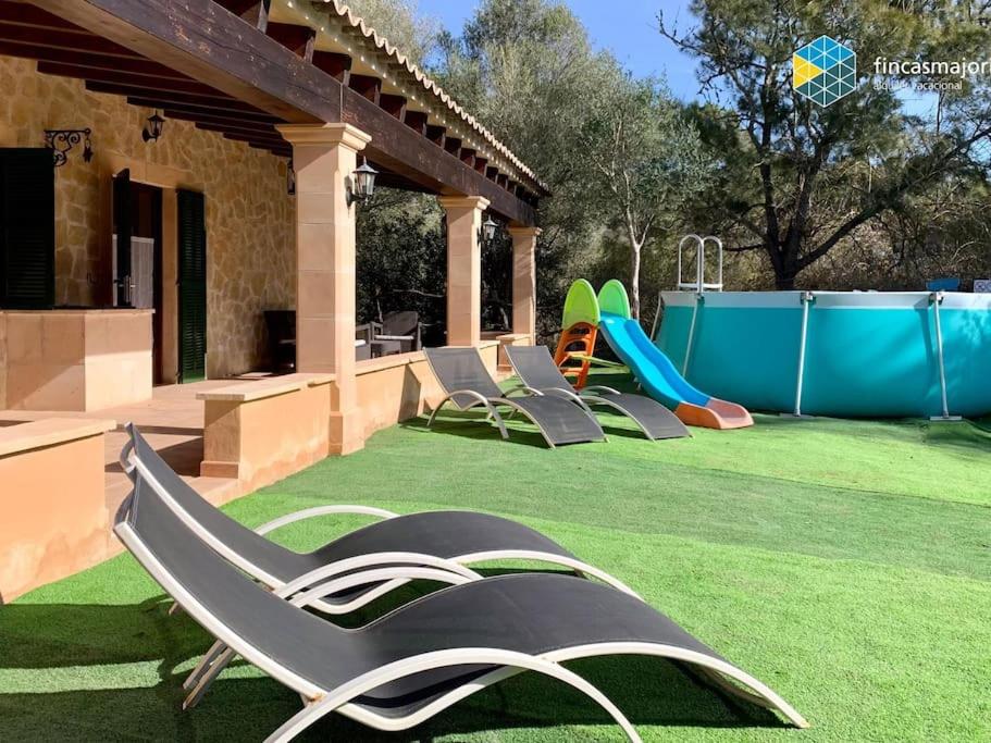 un patio trasero con un parque infantil con sillas y un tobogán en Cas rellotger country house, en Llucmajor