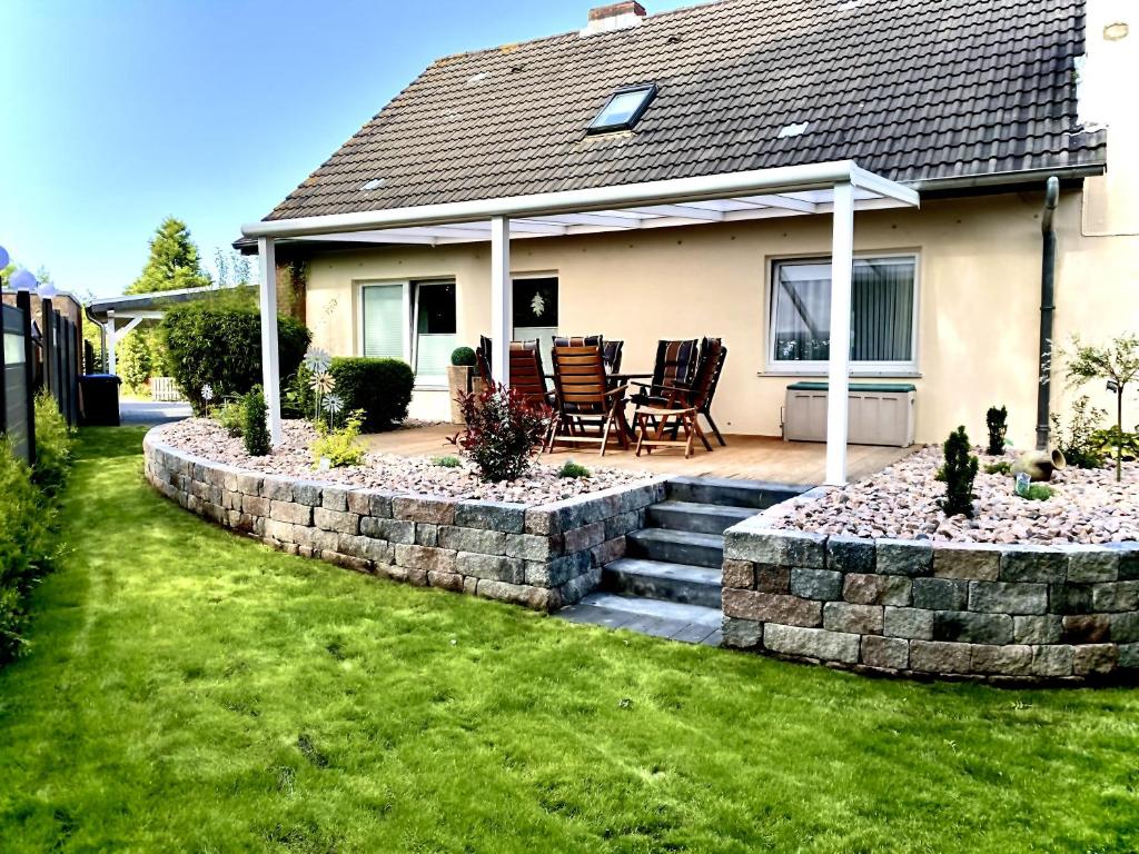 een huis met een steunmuur en een patio bij Nordsee Ferienwohnung 9 Personen in Wangerland