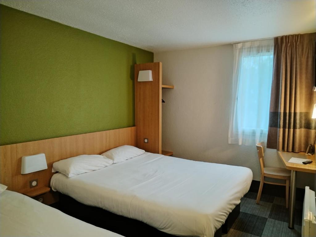 a hotel room with two beds and a window at Hotel Inn Design Montluçon in Montluçon