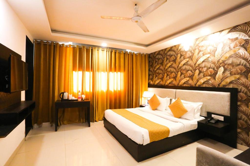 ニューデリーにあるHotel Aashiyana New Delhiのベッドと大きな窓が備わるホテルルームです。