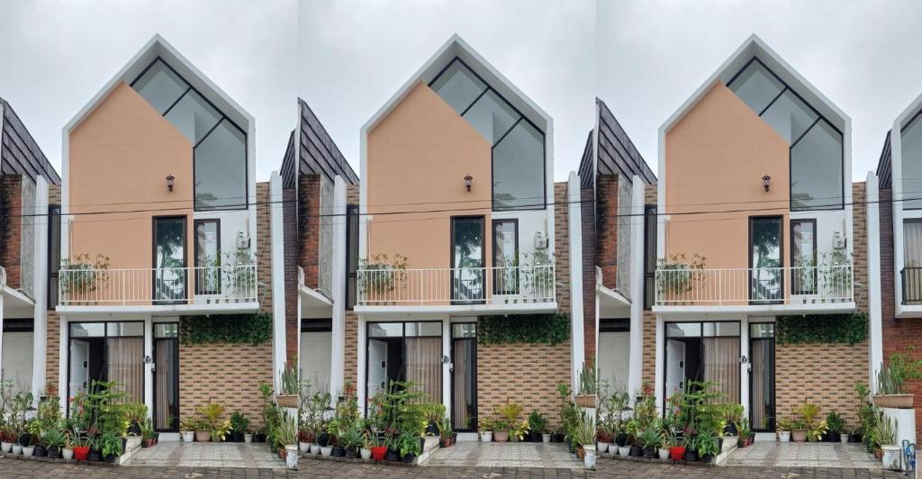 un edificio de apartamentos con balcones y plantas en IbLink Homestay Family Homestay di Dau Malang, en Malang