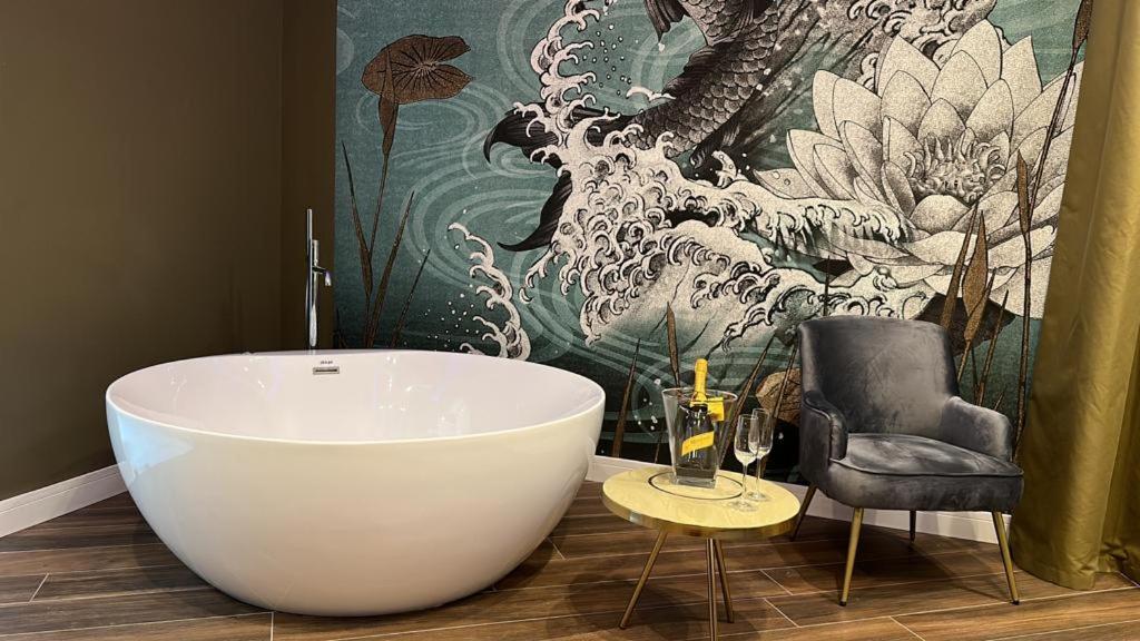 a bathroom with a large white tub and a chair at PALAZZO CHINIAL in Torre del Greco