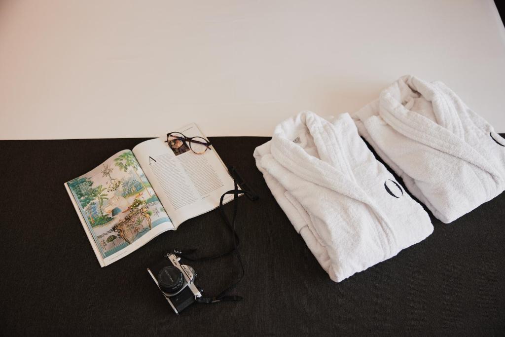 a pair of glasses and a book and a pair of towels at HO Ciudad de Jaén in Jaén