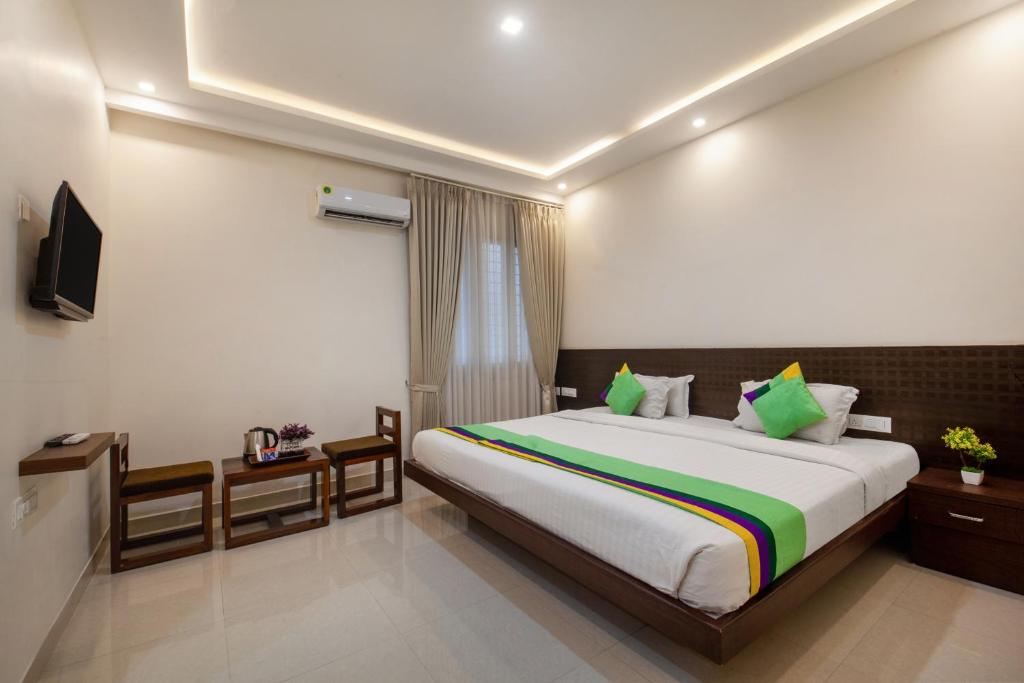 1 dormitorio con 1 cama grande y TV en Treebo Trend Sans Sarav Kushalnagar en Madikeri