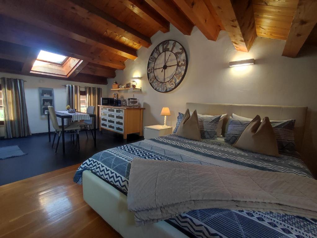 una camera da letto con un grande letto con un orologio sul muro di Torre Cà Emo - Dormire a Serravalle a Vittorio Veneto