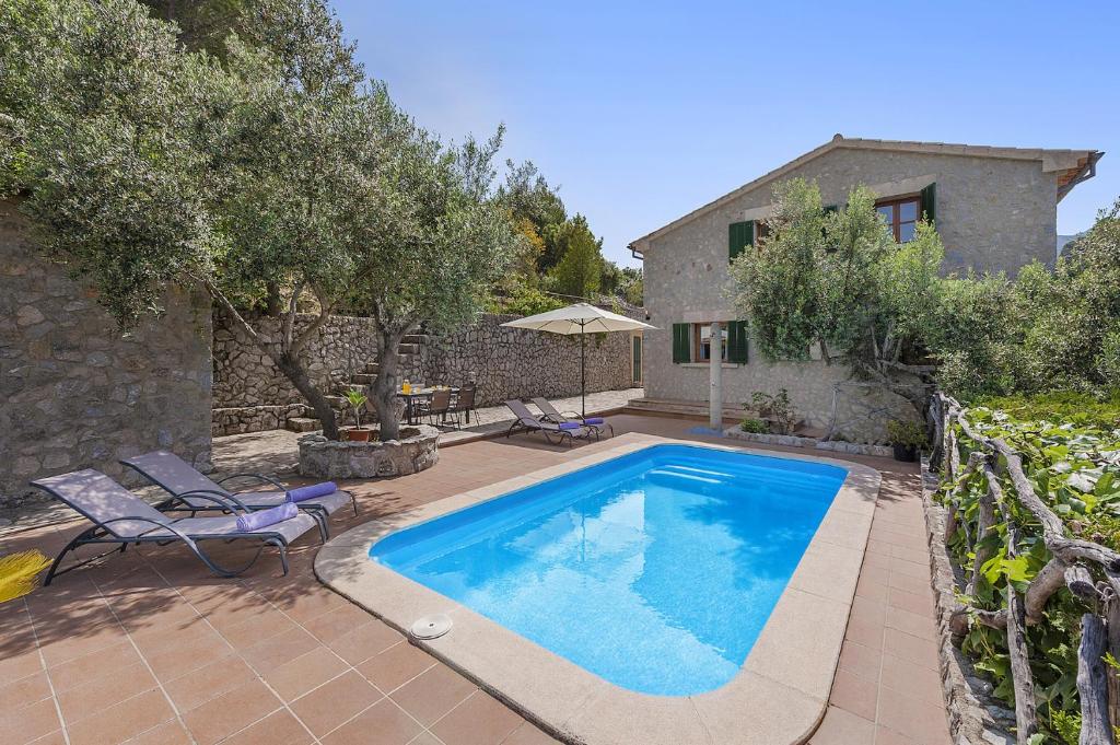 a swimming pool in front of a house at Villa Es Barracar in Selva