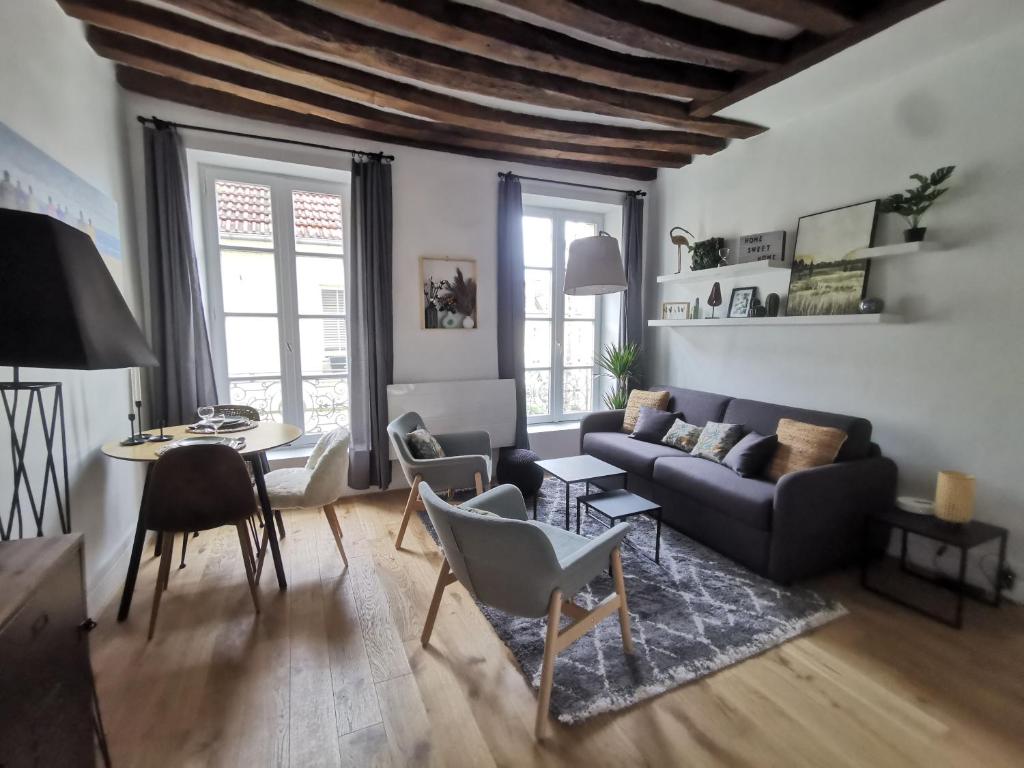 uma sala de estar com um sofá e uma mesa em Saint-Ger, what else ! em Saint-Germain-en-Laye