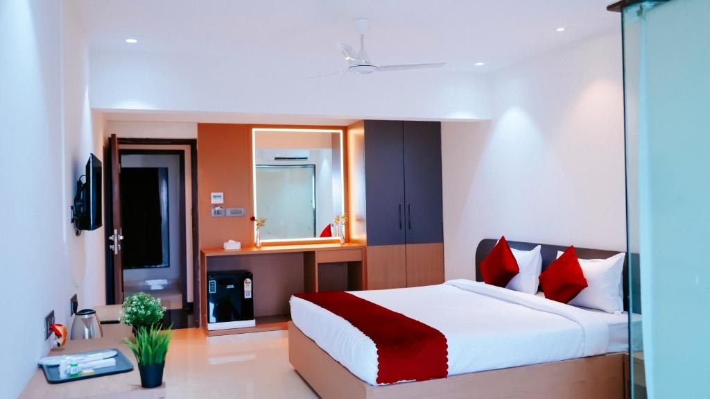 a bedroom with a large bed with red pillows at Hsquare Hotel Andheri West in Mumbai