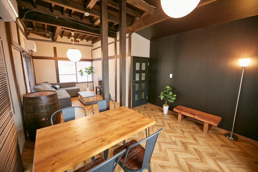 salon z drewnianym stołem i krzesłami w obiekcie Hakone Yumoto Base w mieście Hakone