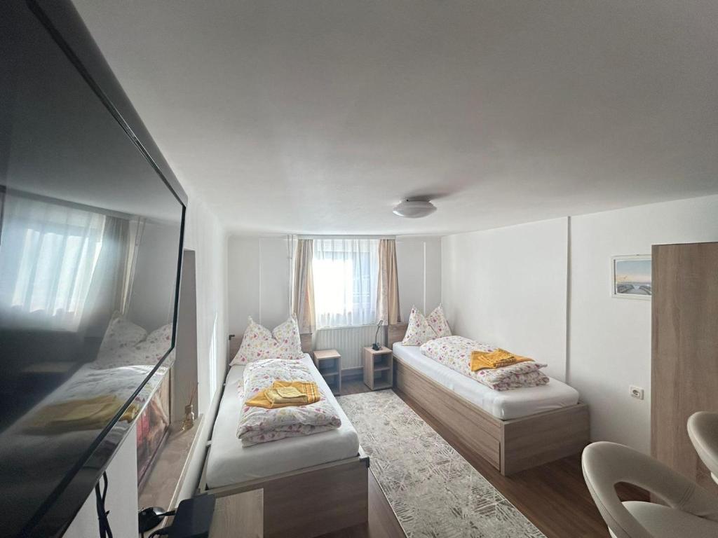 グラーツにあるApartment don boscoの小さな部屋で、ベッド2台、鏡が備わります。