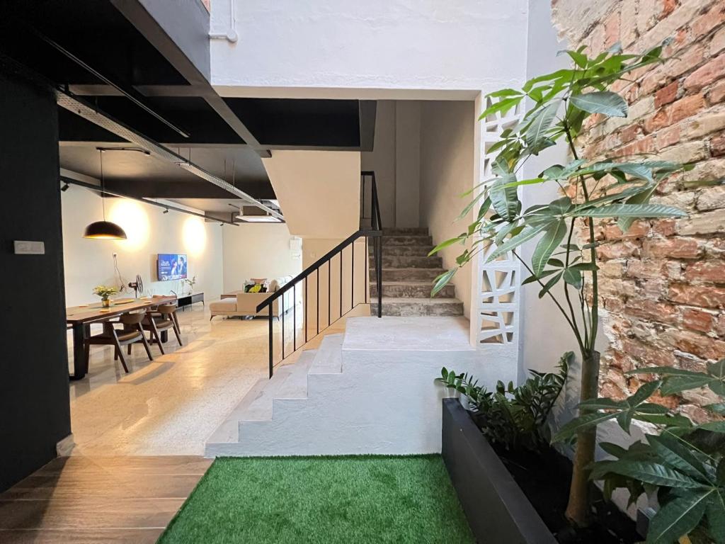 a room with a staircase and a brick wall at Galaria 4BR 17Pax NearTC, DinosaurLand, PS4, Netflix in Kuantan