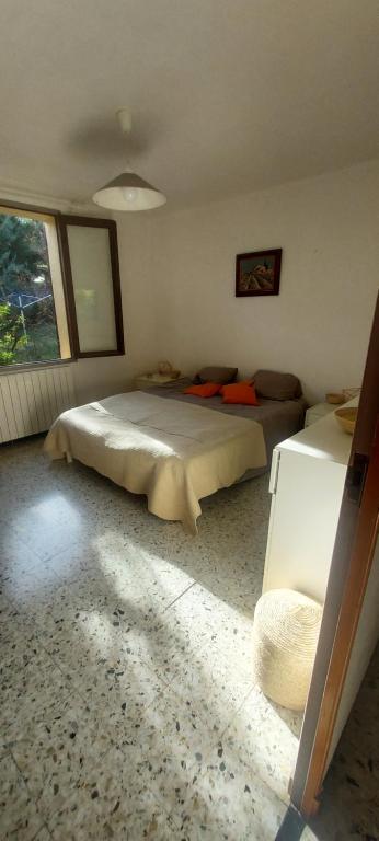 a bedroom with a large bed and a window at Villa Maison de campagne 04 Vacheres Luberon 3 chambres 8 personnes in Vachères