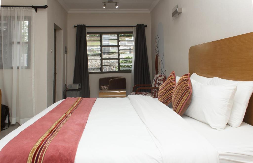 a bedroom with a large bed and a window at Cedar Place in Blantyre