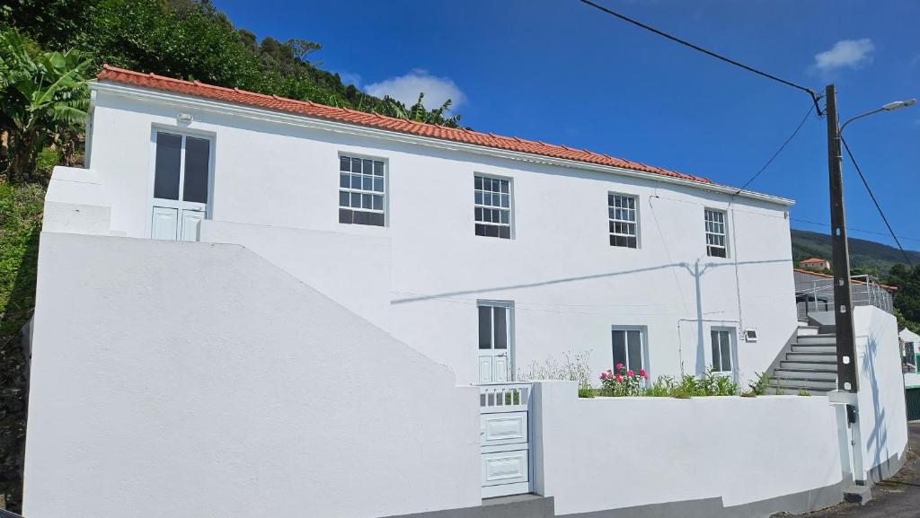 Casa Branca في Ribeiras: بيت ابيض بسياج ابيض