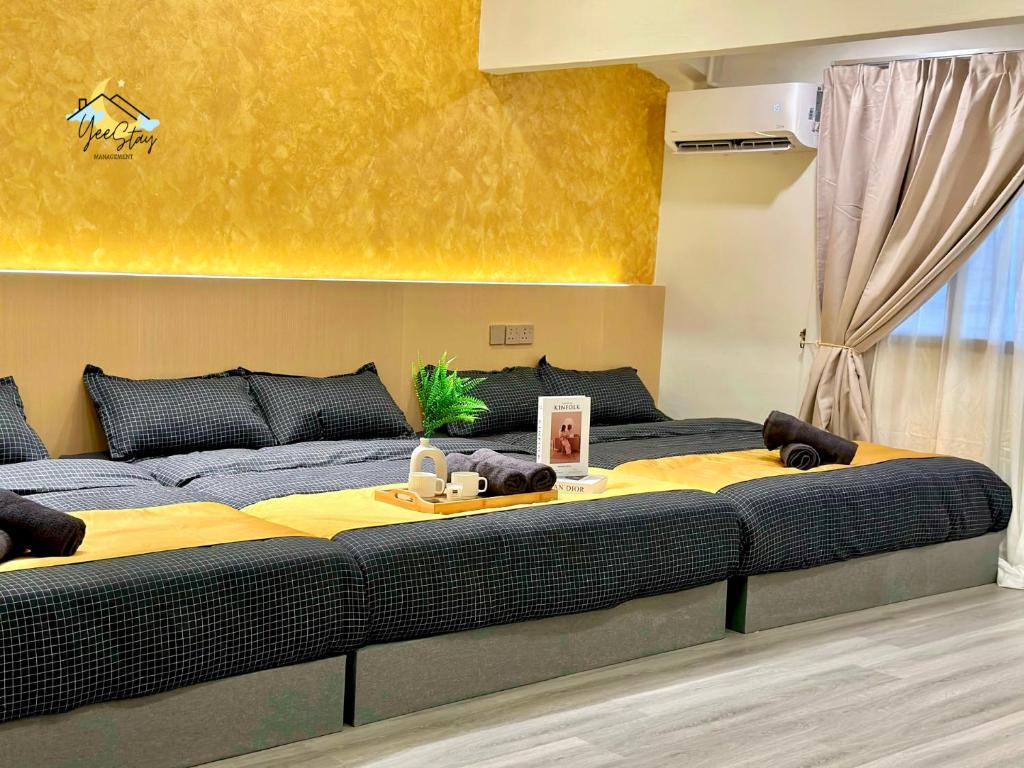 2 große Betten in einem Schlafzimmer mit gelben Wänden in der Unterkunft Kota Laksamana Homestay-22pax with Karaoke,Arcade Game,Table Pool in Malakka