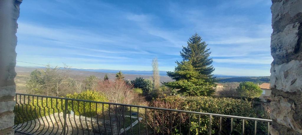 a balcony with a view of a tree and mountains at Villa Maison de campagne 04 Vacheres Luberon 3 chambres 8 personnes in Vachères