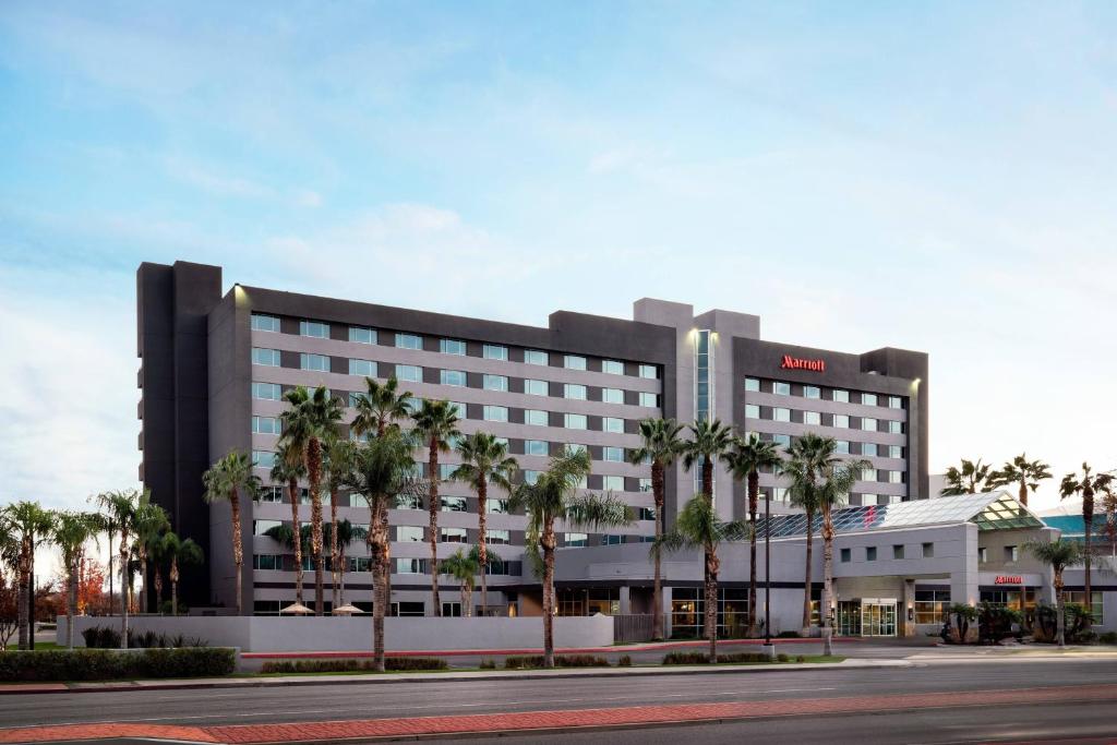 a large building with palm trees in front of it at Bakersfield Marriott at the Convention Center in Bakersfield
