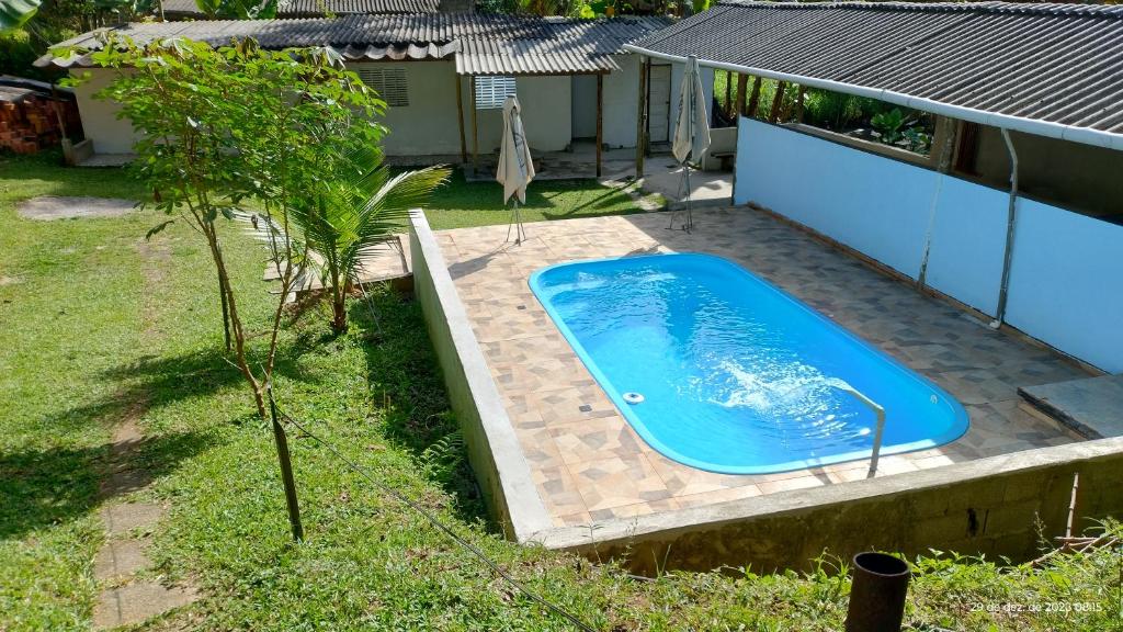 een zwembad in een tuin naast een huis bij ESPAÇO SHEHERAZADE - PISCINA E LAZER in Juquitiba