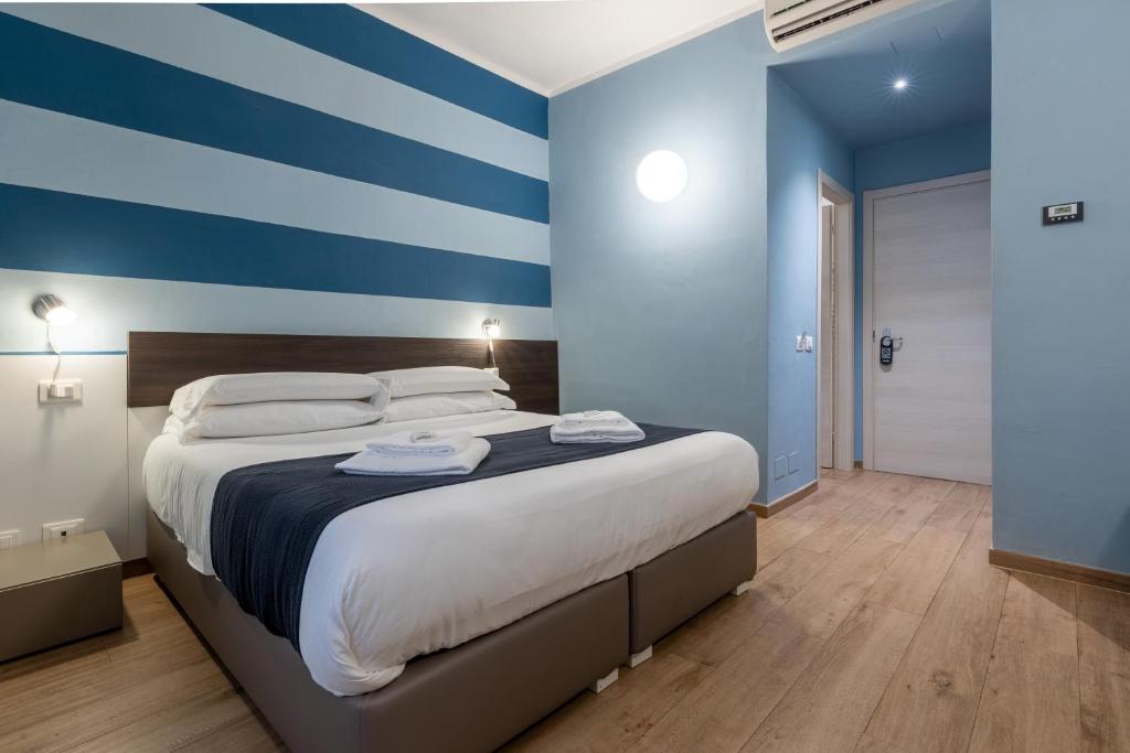 een slaapkamer met een groot bed met blauwe en witte strepen bij La Loggia de' Banchi in La Spezia