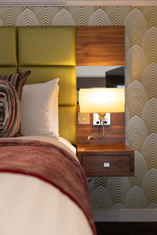 a bedroom with a bed and a yellow headboard at Best Western Mornington Hotel Hyde Park in London