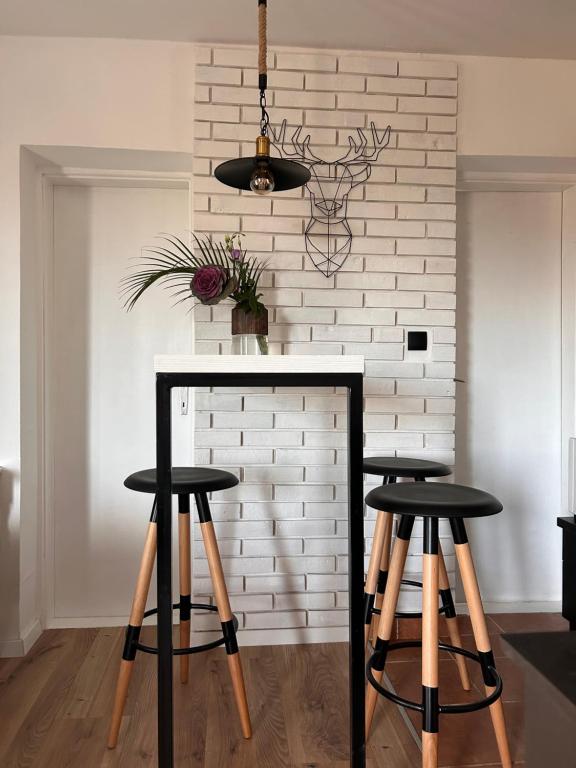 una cocina con 2 taburetes y una pared de ladrillo blanco en Breza Vacation Home 