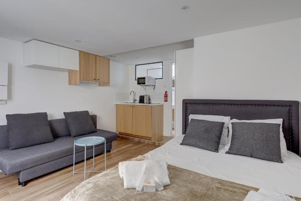 a living room with a bed and a couch at 135 Suite Franck - Charmant Studio à Paris in Paris