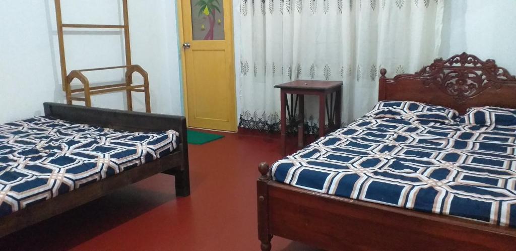 - une chambre avec 2 lits et une porte jaune dans l'établissement Lions Villa & Resort, à Deniyaya