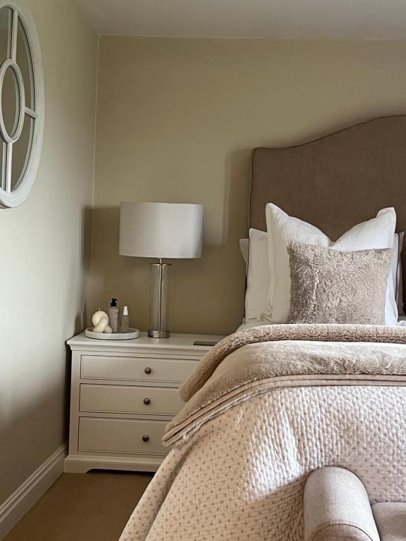 a bedroom with a bed with a lamp on a nightstand at Church Gate Farm in Harrogate