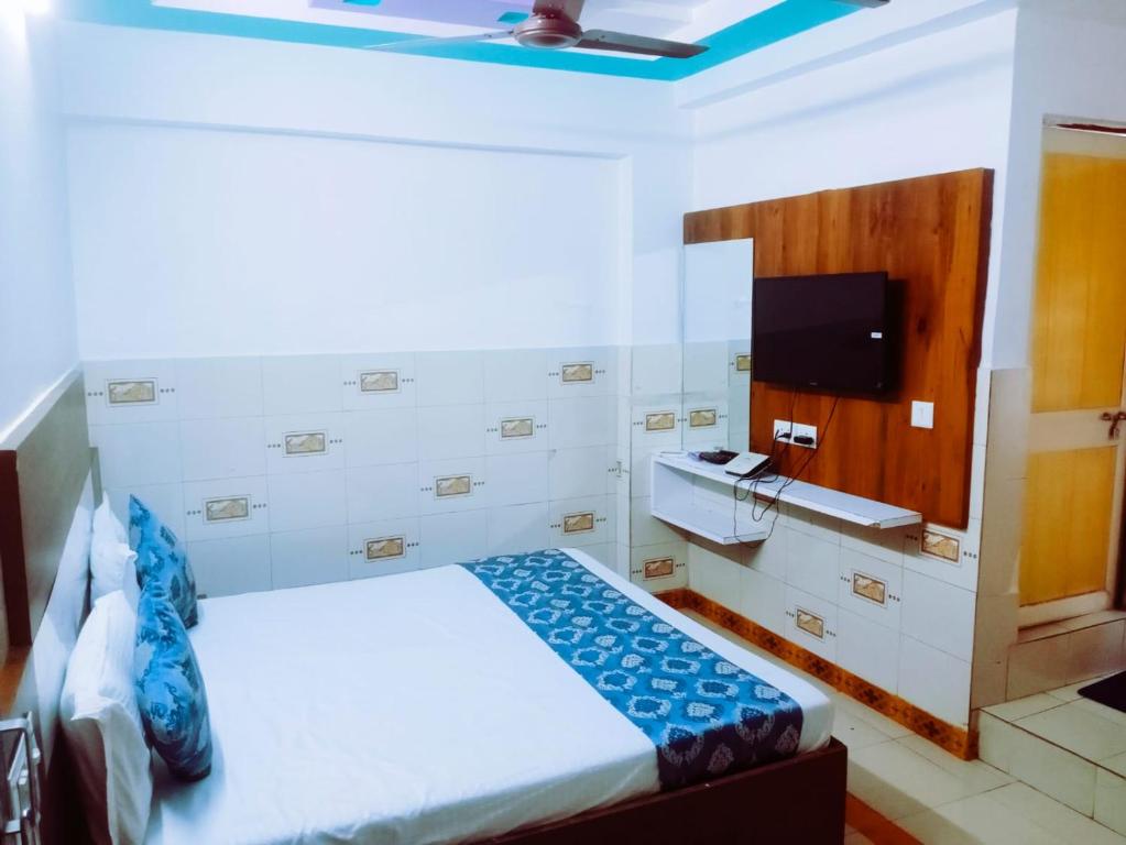 a hotel room with a bed and a tv at HOTEL ASHADEEP in Ahmedabad