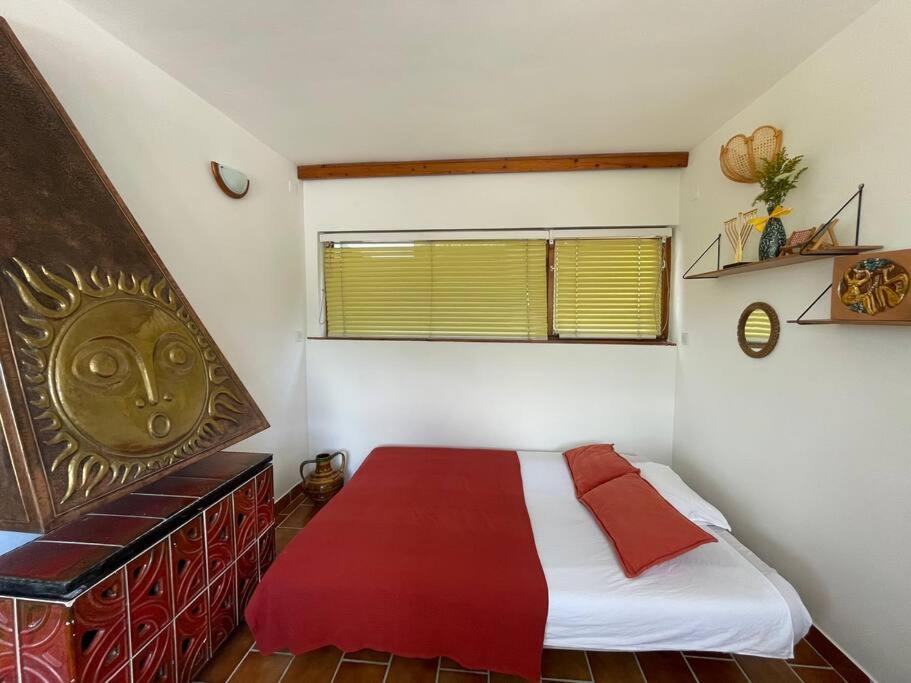 a bedroom with a large bed with red and white sheets at Dömös Cube - kiadó nyaraló kilátással a Dunakanyarra in Dömös