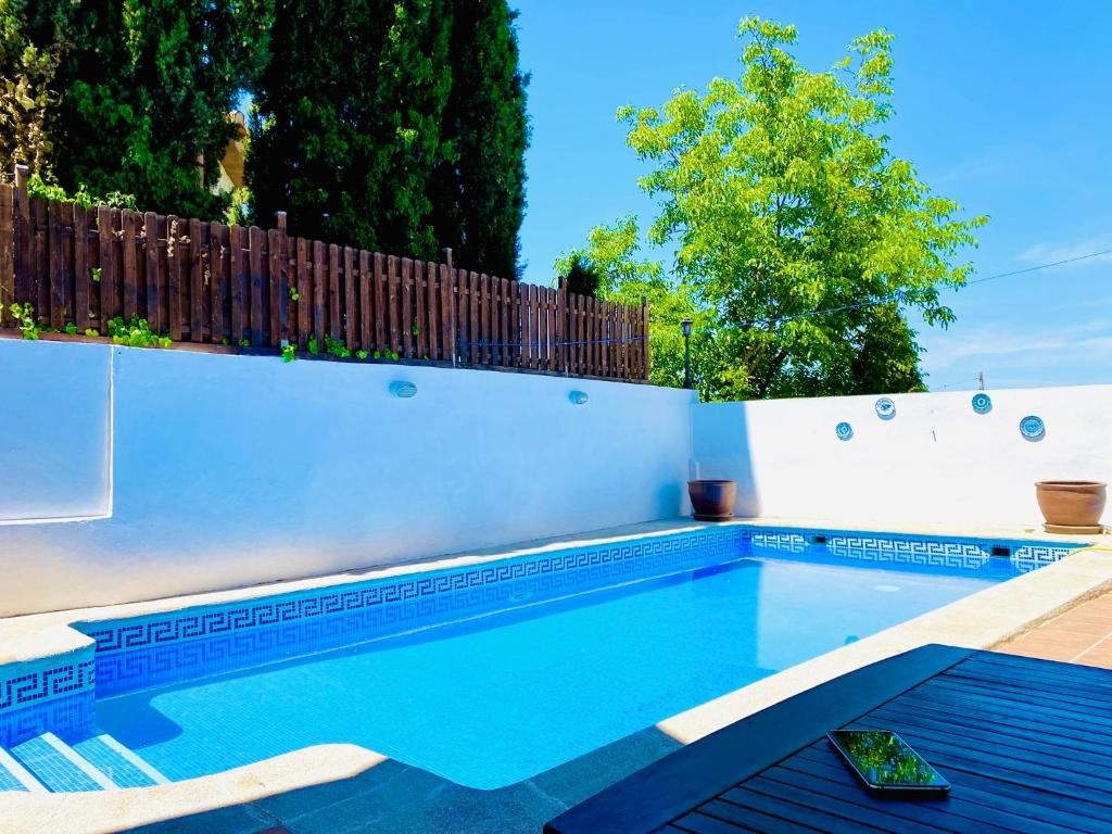 a swimming pool in a backyard with a fence at Mirador Del Olivar in Gójar