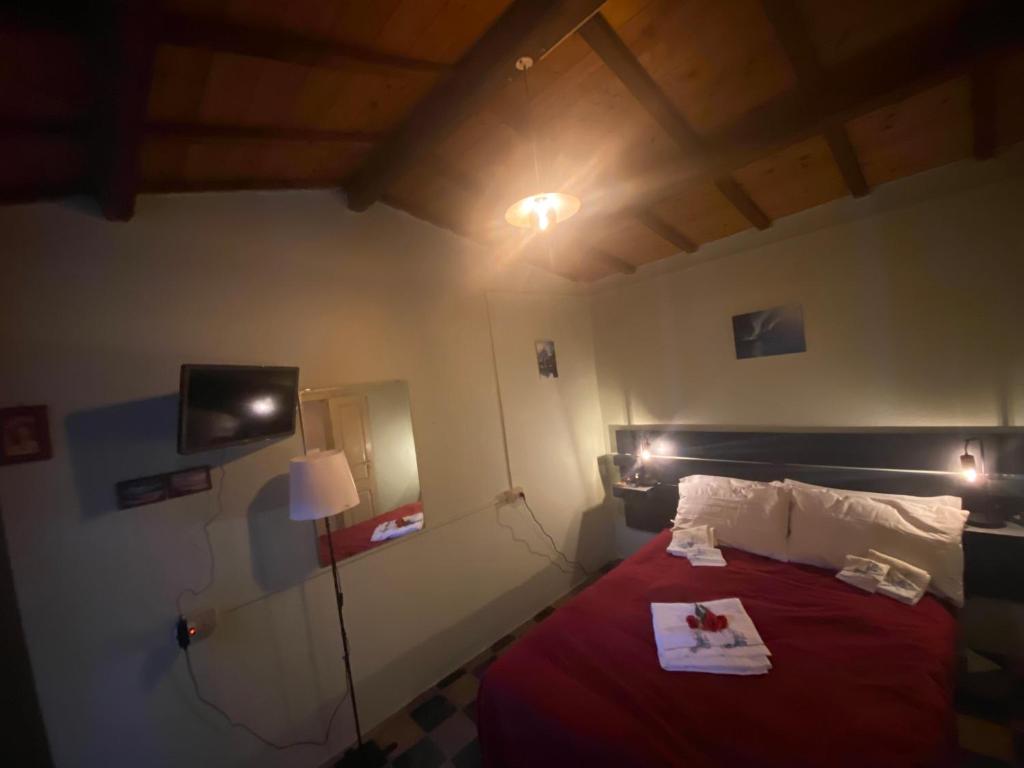Camera con letto e piumone rosso di Peppina Home a Ghilarza