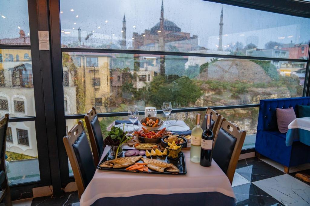 a table with food and wine glasses and a view of the city at Villa Sofia in Istanbul