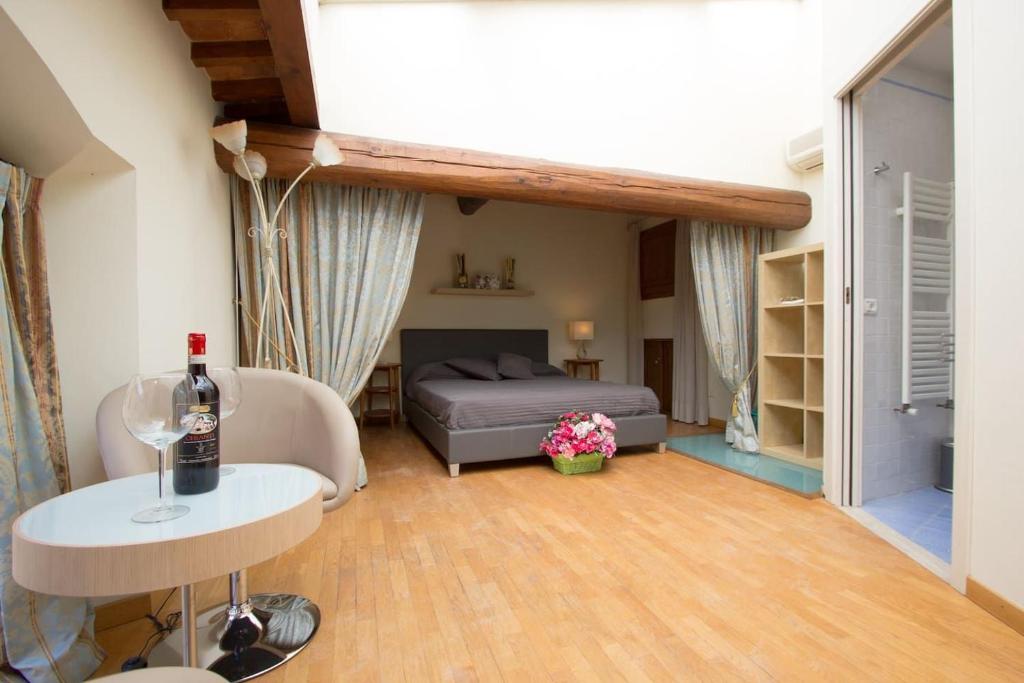 Cette chambre comprend un lit et une table avec une bouteille de vin. dans l'établissement Santa Reparata Loft Florence, à Florence
