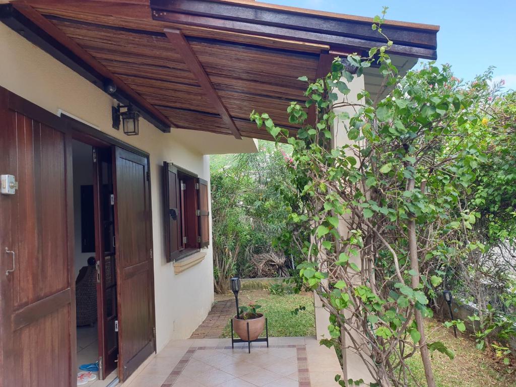 an entrance to a house with a wooden roof at Villa Delice, privée et luxueuse in Rivière Noire