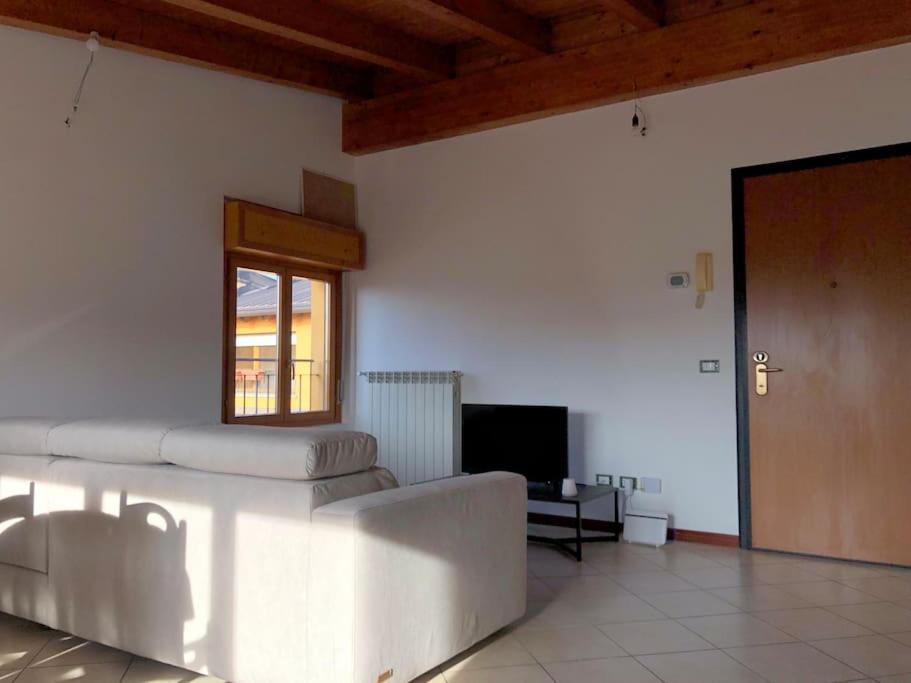 sala de estar con sofá y ventana en Mansarda Raffaello, en Seregno