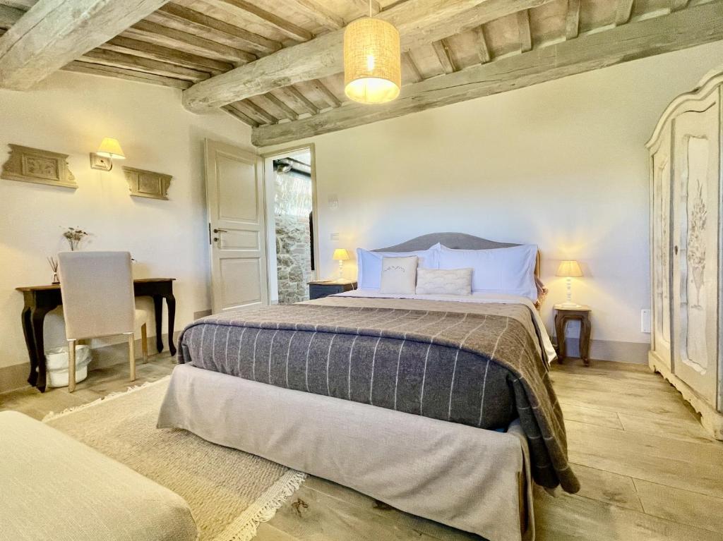 a bedroom with a large bed and a desk at Vento d’Orcia in Pienza
