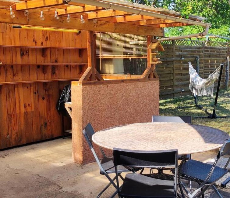 un patio avec une table et des chaises et une clôture dans l'établissement Le temps d'une pause dans l'Yonne, à Charmoy