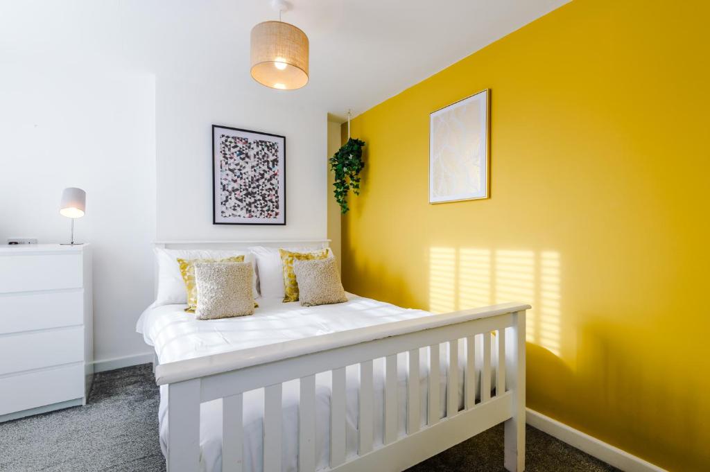 um berço branco num quarto com uma parede amarela em Large 7 bedroom town house in Chester City Centre em Chester