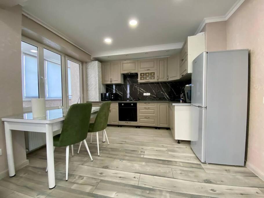 a kitchen with a refrigerator and a table and chairs at Family Haven Apartment in Chişinău