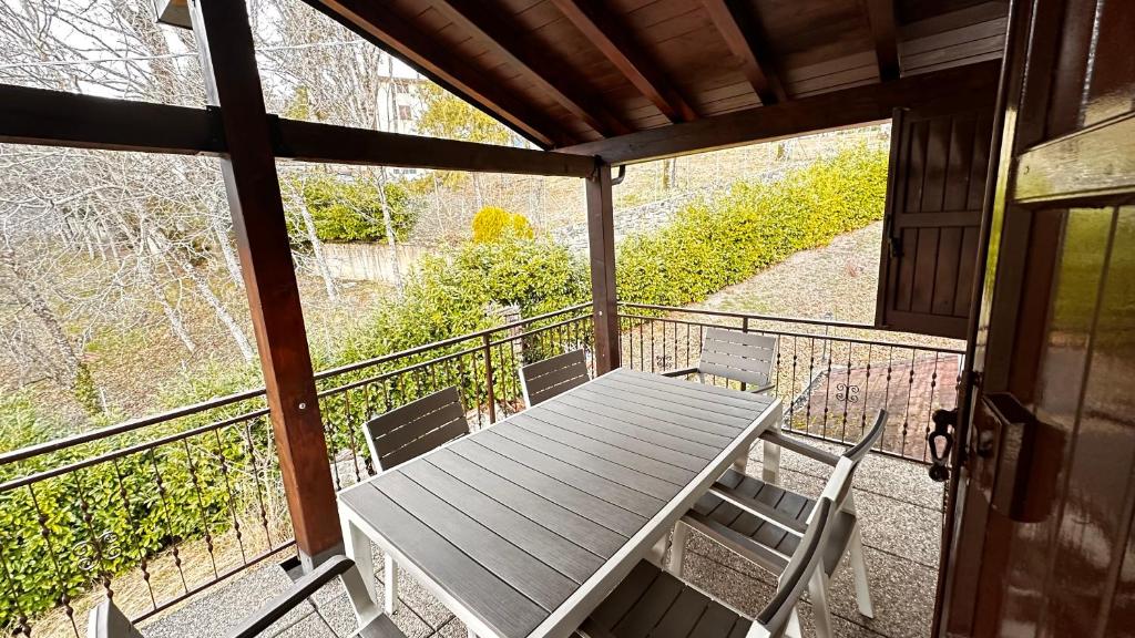 - une terrasse couverte avec une table et des chaises sur un balcon dans l'établissement Appartamento Casa Vapi, à Pievepelago