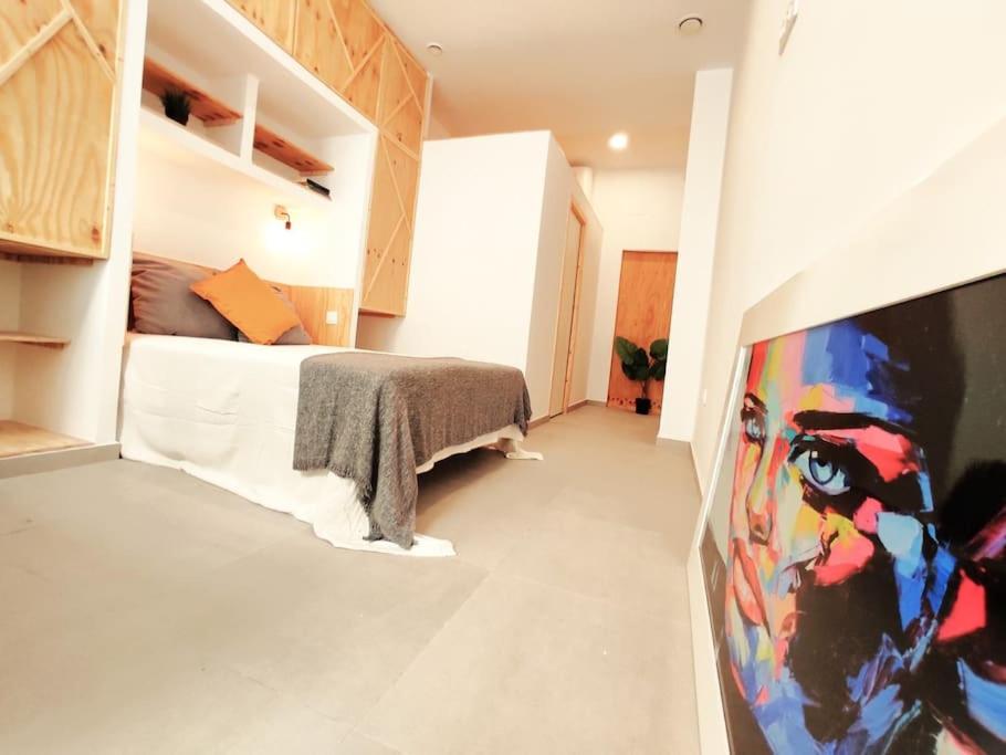 a bedroom with a bed and a painting on the wall at Acogedor loft central en Valencia_ calamochaA in Valencia