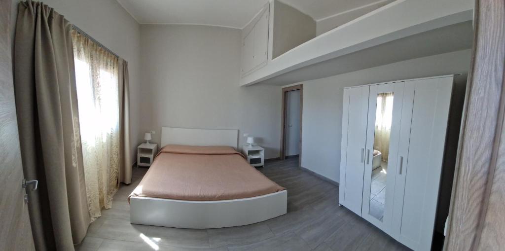 Casa vacanze Villa Marta في سان جورجيو ماجيوري: غرفة نوم بسرير في غرفة بيضاء