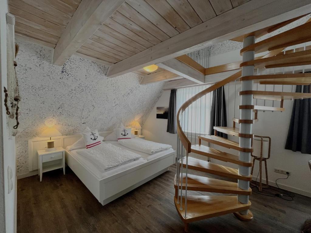 ein Schlafzimmer mit einem Bett und einer Wendeltreppe in der Unterkunft Hotel Anka in Norddorf