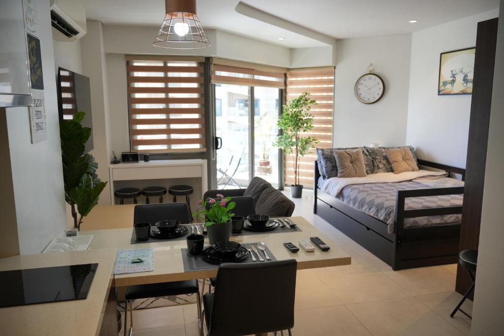 una cucina e un soggiorno con tavolo e divano di Dominiks Elegant Apt Ocean Views, Pool at Tambuli Resort 10 Floor a Maribago