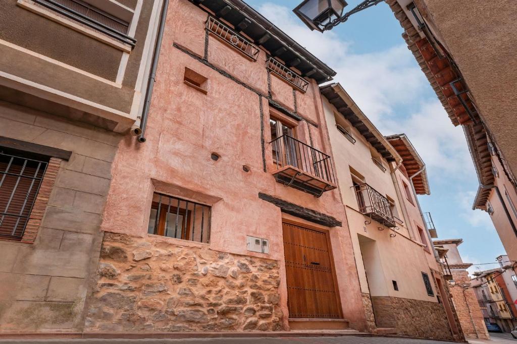 un edificio con una puerta marrón en una calle en CASA RURAL EL GARROTE, en Gea de Albarracín