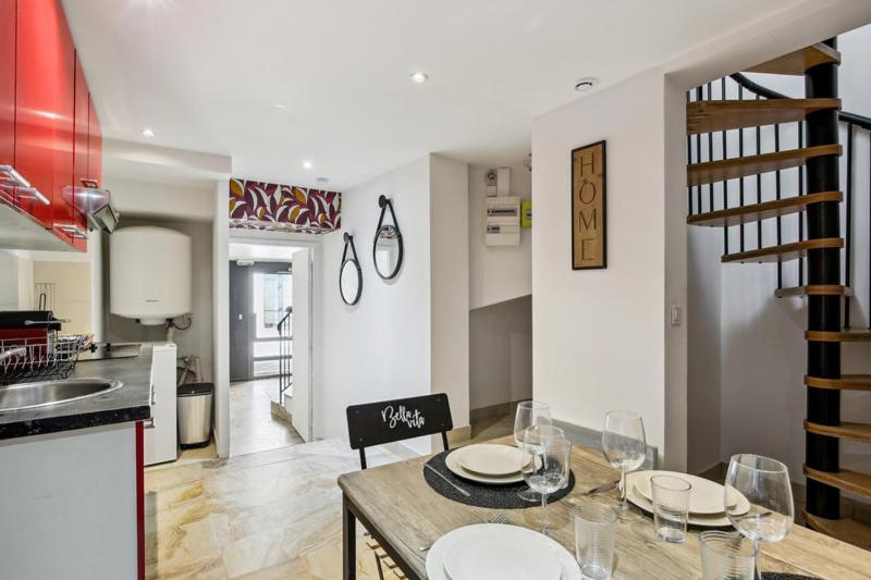 a kitchen with a table with plates and wine glasses at 851 Suite Beautiful Superb Apartment in Asnières-sur-Seine