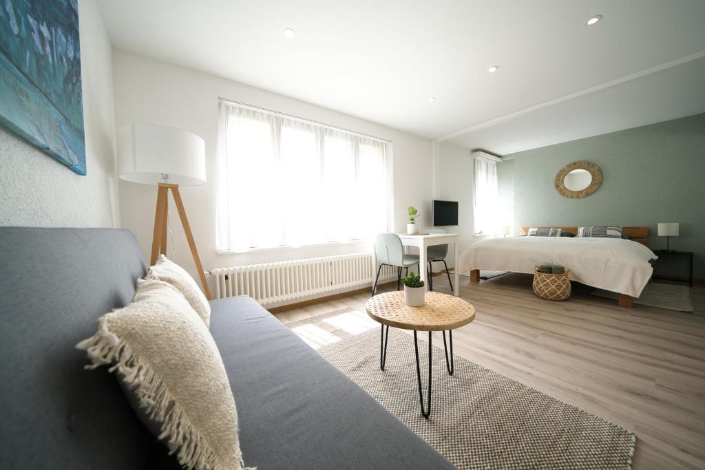 een woonkamer met een bed, een bank en een tafel bij Bijou Studio with Ambiance near Lake in Faulensee